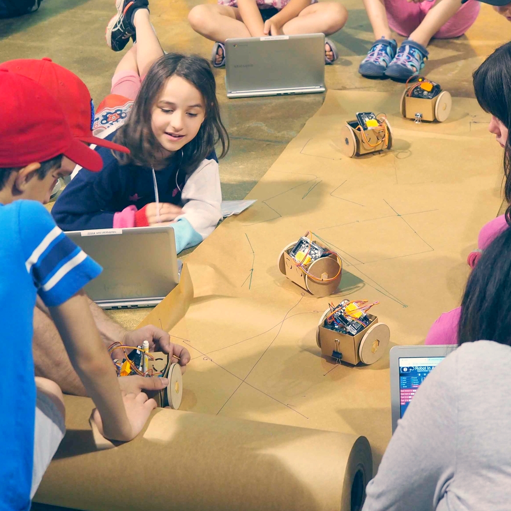 Robot In A Can workshop table with students building